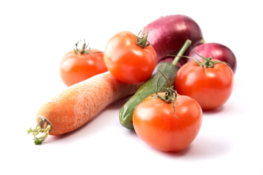 Cucumber tomatoes and an onions on a white background