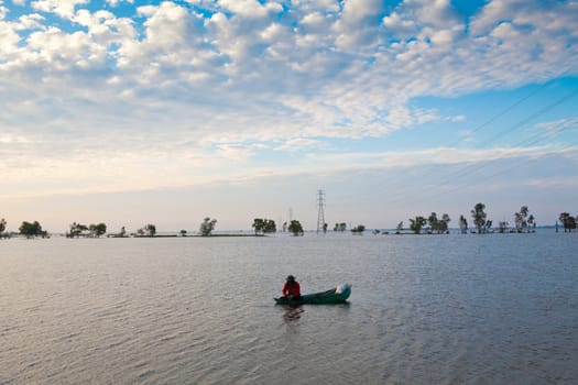 A fisherman with a boat on the flood in Thailand