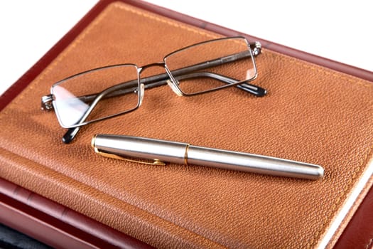 Organizer glasses and fountain pen on a white background