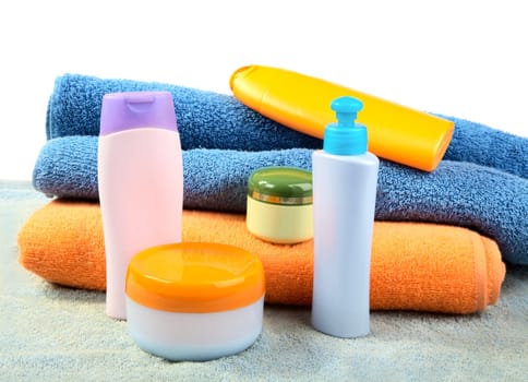 Terry towels and tubes with cosmetics isolated on a white background