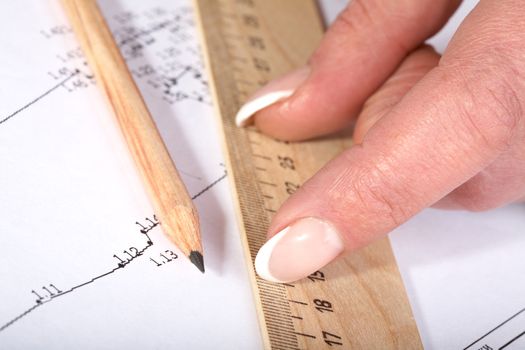 Female hands with a ruler and  pencil on the drawing