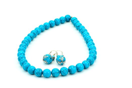 Blue beads and earrings on a white background