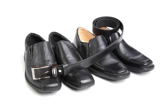 Two pairs black man's shoe and a belt on  white background