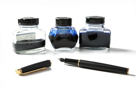 Small bottles with ink and  fountain pen on a white background