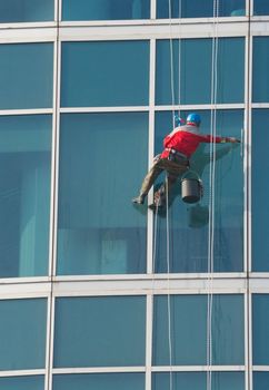 Climber - window cleaner perform the work at wall of an office building