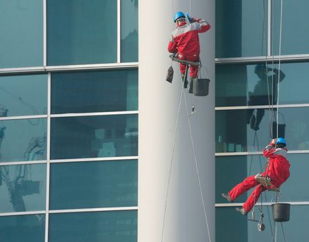 Climbers - window cleaners perform the work at wall of an office building