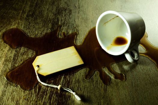 spilled coffee from a white cup on a grunge table with room for text