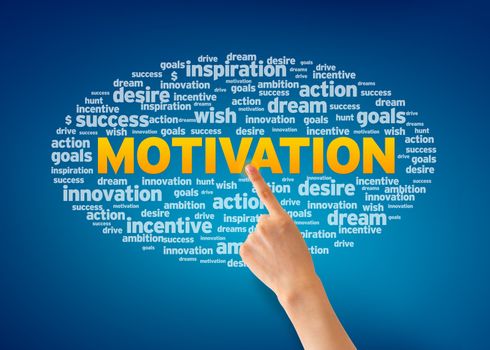 Hand pointing at a Motivation word cloud on blue background.