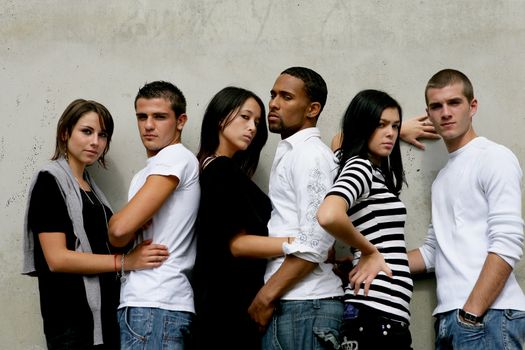 Trendy young people gathered by wall