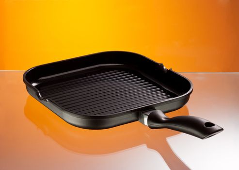 new pan with grill over hot color background