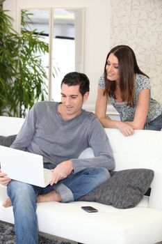 Couple at home looking at a laptop