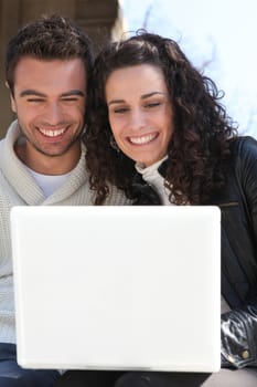Couple outdoors with laptop