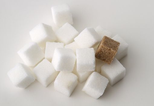 stack of white sugar cube with one brown sugar cube