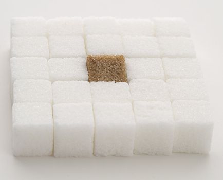 white sugar cube with one brown sugar cube place in a square shape