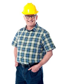 Smiling matured architect posing with hands in pocket. Wearning hard-hat