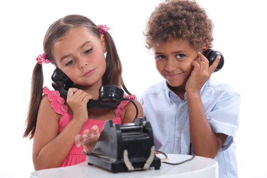 Little boy and girl with old fashioned telephone