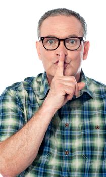 Cropped image of handsome old man with finger on his lips. Silence concept