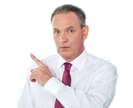 Portrait of senior businessman pointing backwards isolated on white background