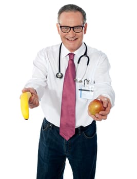 Senior doctor offering fruits to you for your good health