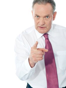 Portrait of an angry middle aged businessman in suit pointing at you isolated over white background