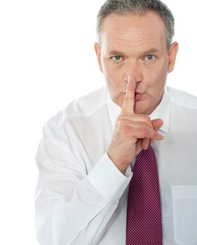 Senior businessman gesturing silence