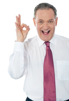 Happy satisfied businessman with okay hand sign isolated on white background