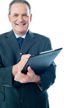 Businessman writing on clipboard while facing camera