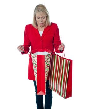 Lady surprised to see empty shopping bag. Looking down