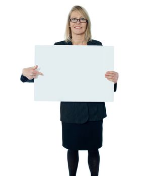 Corporate woman pointing towards blank billboard, isolated on white