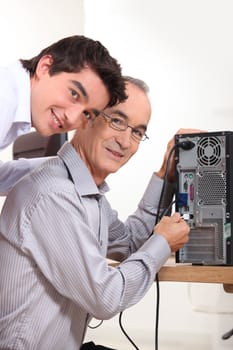 grandson and grandfather connecting a computer