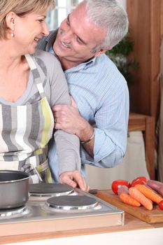 Smiling mature couple cooking