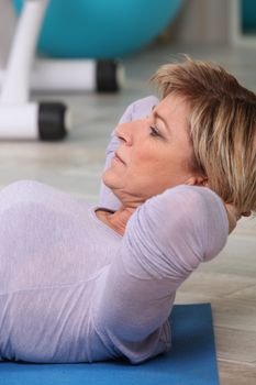 Woman doing sit-ups on gym mat