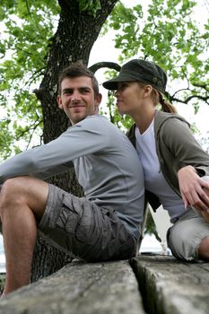 Couple of hikers sitting on a table outdoors