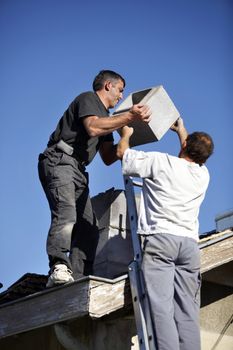 Roofers installing chimney