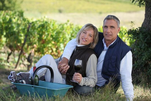 Couple sitting in front of vineyard