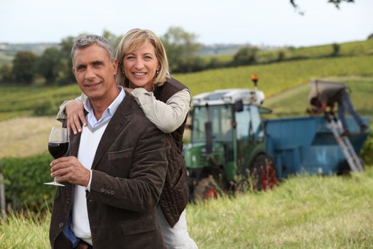 Couple with wine glass in front of vineyard