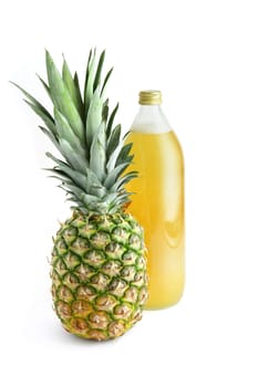 Glass bottle of juice next to pineapple