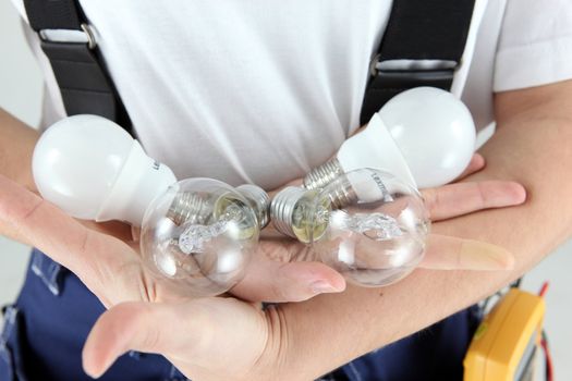 Female electrician holding light bulbs
