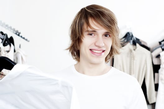 man in shop of clothes, smiles and is happy with purchases