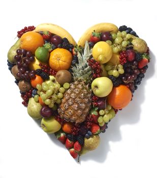 Overhead view of various types of fruit in heart shape on white background