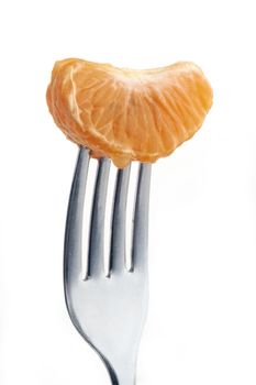 slice of orange pierced on a fork against plain background