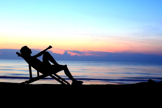 deckchairs and man on beach at sunset