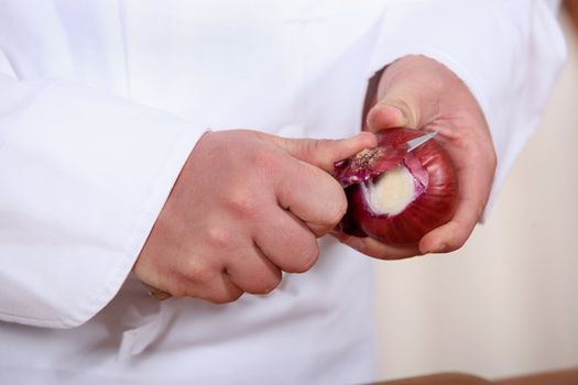 Male hands peeling onions