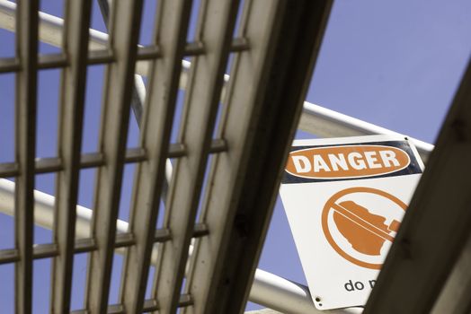 a danger sign as viewed from under the stairs