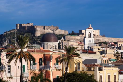 View from sea of Milazzo town in Sicily, Italy, with medieval castle on hilltop