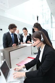 Female receptionist using a headset and laptop computer