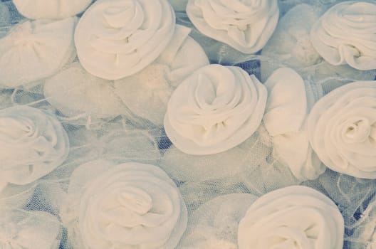 Grungy shot of cloth white roses on wedding gown