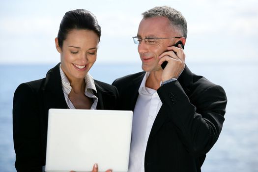 Businesspeople outdoors with laptop