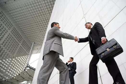Businessmen shaking hands outside