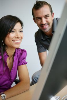 happy young woman and man working on laptop